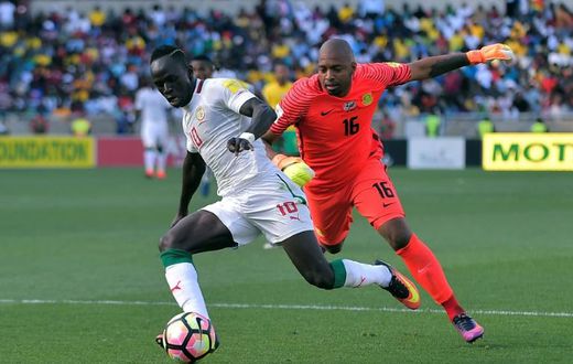 South Africa goalkeeper Itumeleng Khune (R) chases Senegal star Sadio Mane during a 2018 World Cup qualifer.