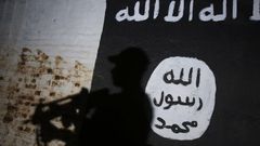 A member of the Iraqi forces walks past a mural bearing the logo of the Islamic State (IS) group in a tunnel that was reportedly used as a training centre by the jihadists, on March 1, 2017, in the village of Albu Sayf, on the southern outskirts of Mos...