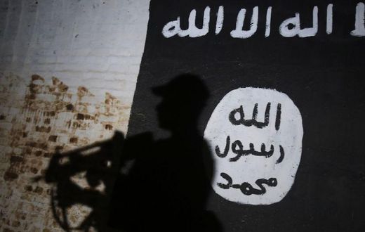 A member of the Iraqi forces walks past a mural bearing the logo of the Islamic State (IS) group in a tunnel that was reportedly used as a training centre by the jihadists, on March 1, 2017, in the village of Albu Sayf, on the southern outskirts of Mos...