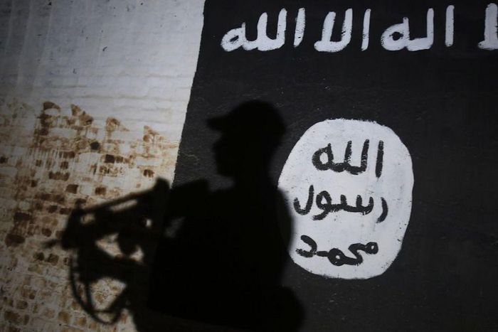 A member of the Iraqi forces walks past a mural bearing the logo of the Islamic State (IS) group in a tunnel that was reportedly used as a training centre by the jihadists, on March 1, 2017, in the village of Albu Sayf, on the southern outskirts of Mos...