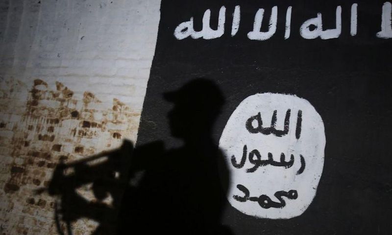A member of the Iraqi forces walks past a mural bearing the logo of the Islamic State (IS) group in a tunnel that was reportedly used as a training centre by the jihadists, on March 1, 2017, in the village of Albu Sayf, on the southern outskirts of Mos...