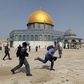 A member of Israeli police runs after a cameraman during clashes with Palestinians at the compound that houses Al-Aqsa Mosque, known to Muslims as Noble Sanctuary and to Jews as Temple Mount, in Jerusalem's Old City, May 10, 2021.