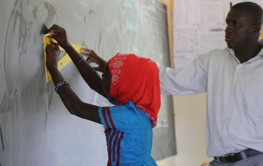 Sénégal : une jeune fille s'exerce en classe sous la supervision d'un enseignant