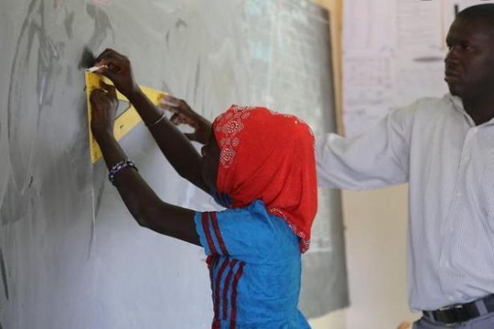 Sénégal : une jeune fille s'exerce en classe sous la supervision d'un enseignant