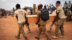 Des militaires burkinabés portent un cercueil lors de l'enterrement des 27 soldats tués alors qu'ils escortaient 207 véhicules dans un convoi à Gaskinde