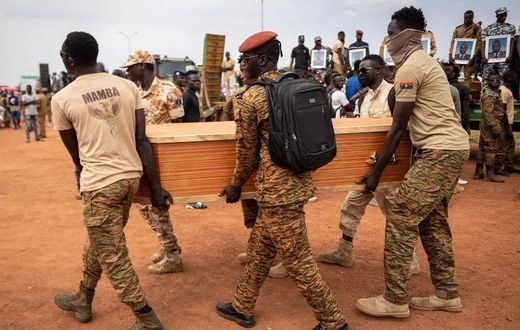 Des militaires burkinabés portent un cercueil lors de l'enterrement des 27 soldats tués alors qu'ils escortaient 207 véhicules dans un convoi à Gaskinde
