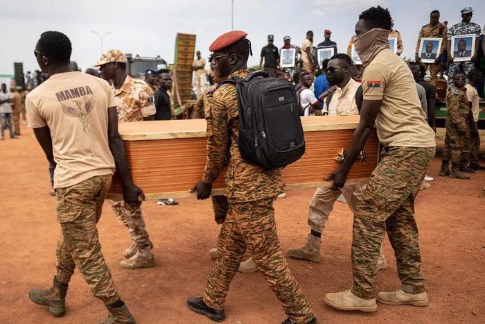 Des militaires burkinabés portent un cercueil lors de l'enterrement des 27 soldats tués alors qu'ils escortaient 207 véhicules dans un convoi à Gaskinde