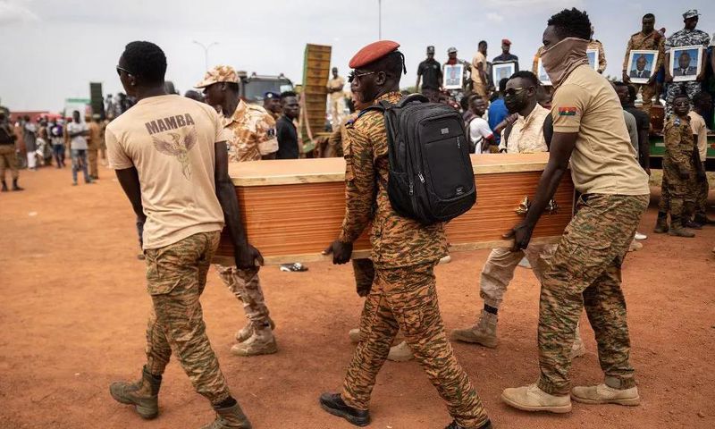 Des militaires burkinabés portent un cercueil lors de l'enterrement des 27 soldats tués alors qu'ils escortaient 207 véhicules dans un convoi à Gaskinde