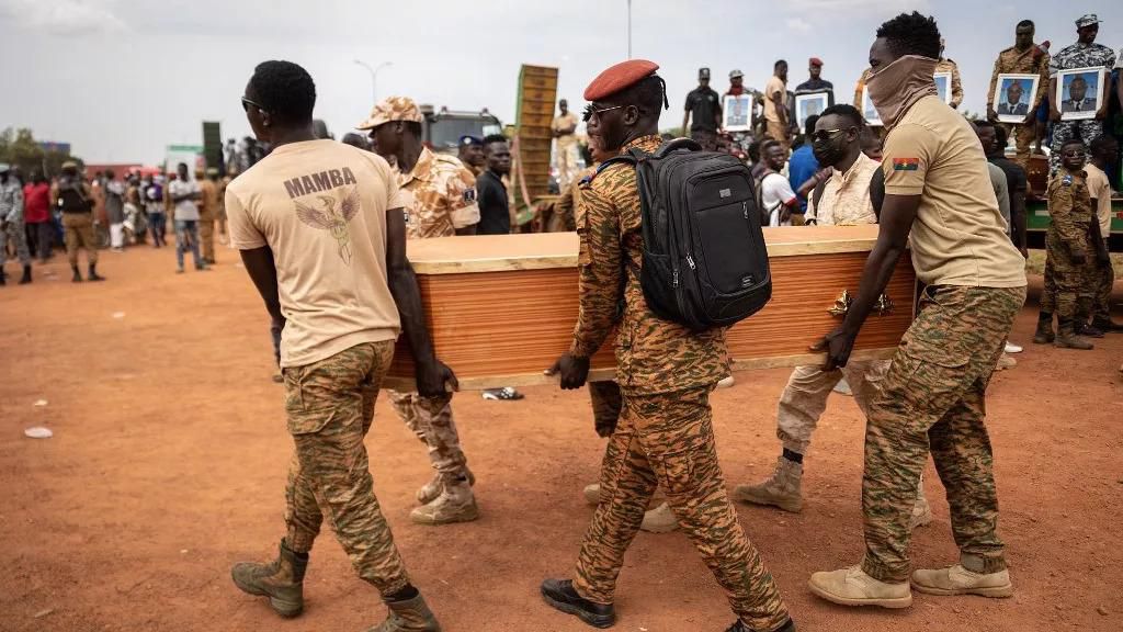 Des militaires burkinabés portent un cercueil lors de l'enterrement des 27 soldats tués alors qu'ils escortaient 207 véhicules dans un convoi à Gaskinde
