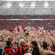 Les supporters du Bayer Leverkusen exultent sur la pelouse de la BayArena après le sacre de leur équipe en championnat d'Allemagne, le 14 avril 2024  AFP INA FASSBENDER