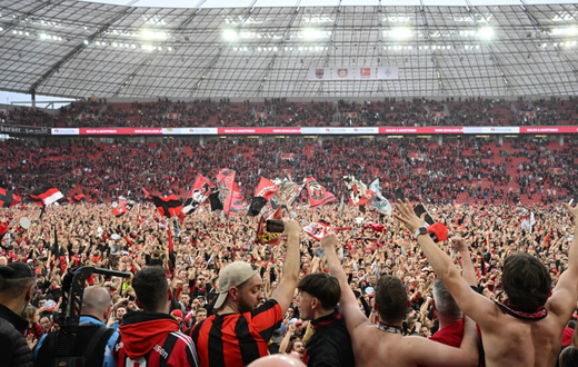 Les supporters du Bayer Leverkusen exultent sur la pelouse de la BayArena après le sacre de leur équipe en championnat d'Allemagne, le 14 avril 2024  AFP INA FASSBENDER