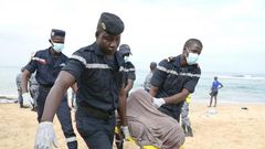 Des sauveteurs portent le corps d'une victime après le naufrage d'une embarcation, le 24 juillet 2023 sur la plage de Ouakam, à Dakar, au Sénégal - AFP SEYLLOU