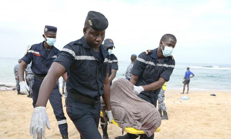 Des sauveteurs portent le corps d'une victime après le naufrage d'une embarcation, le 24 juillet 2023 sur la plage de Ouakam, à Dakar, au Sénégal - AFP SEYLLOU