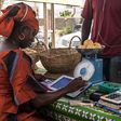 Une femme sur un marché de Dakar traite une commande de légumes à l’aide de sa tablette Weebi © Vincent Tremeau - La Banque mondiale