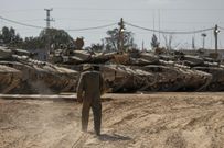 Israeli soldiers work on tanks at a staging ground near the border with the Gaza Strip in southern Israel on April 11, 2024.AP Photo/Tsafrir Abayov