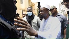 L'opposant sénégalais Ousmane Sonko discute avec des membres de la police devant sa résidence à Dakar, le 17 juin 2022.