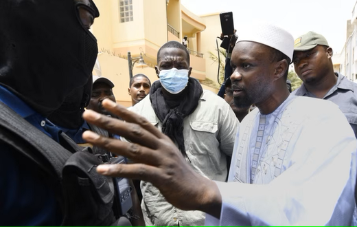 L'opposant sénégalais Ousmane Sonko discute avec des membres de la police devant sa résidence à Dakar, le 17 juin 2022.