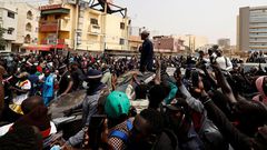 Le chef de l’opposition sénégalaise, Ousmane Sonko, sur le toit d’une voiture après son audience au tribunal à Dakar, le 16 février 2023. © ZOHRA BENSEMRA/REUTERS