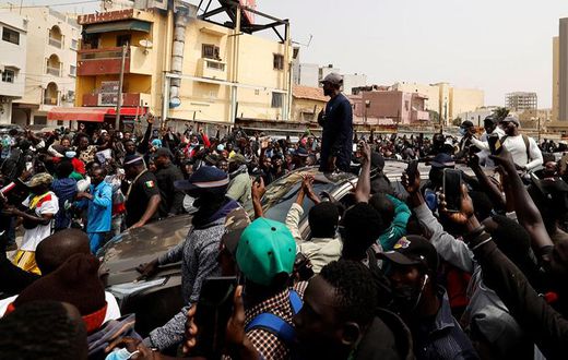 Le chef de l’opposition sénégalaise, Ousmane Sonko, sur le toit d’une voiture après son audience au tribunal à Dakar, le 16 février 2023. © ZOHRA BENSEMRA/REUTERS