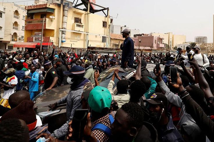 Le chef de l’opposition sénégalaise, Ousmane Sonko, sur le toit d’une voiture après son audience au tribunal à Dakar, le 16 février 2023. © ZOHRA BENSEMRA/REUTERS