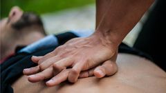 Un homme se trouve à plat pendant que quelqu’un fait la RCR sur sa poitrine nue