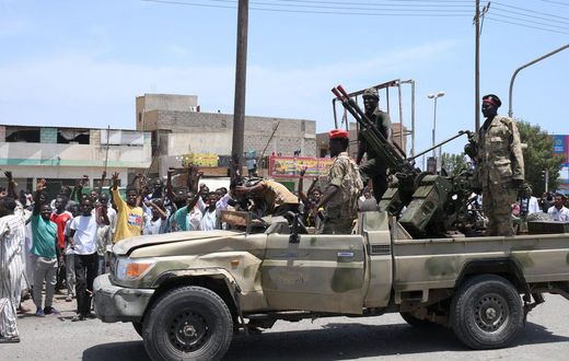 Sudanese greet army soldiers, loyal to army chief Abdel Fattah al-Burhan, in the Red Sea city of Port Sudan on April 16, 2023.AFP via Getty Images