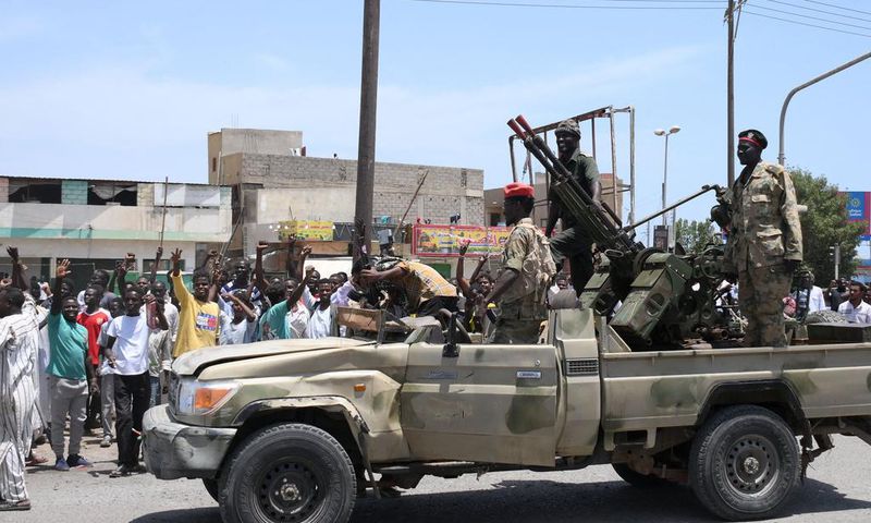 Sudanese greet army soldiers, loyal to army chief Abdel Fattah al-Burhan, in the Red Sea city of Port Sudan on April 16, 2023.AFP via Getty Images