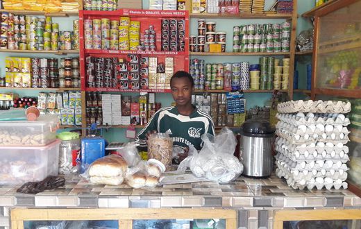 Un jeune vendeur debout au comptoir dans une boutique (image d'illustration)