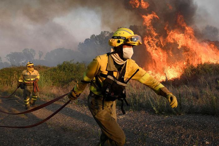 Firefighters try to extinguish a wildfire next to the village of Tabara, near Zamora, northern Spain, on Monday.