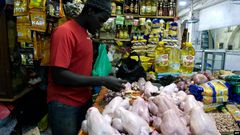 Un vendeur de poulets prépare des viandes à vendre sur un marché de Bambilors à Dakar, le 4 mai 2018. (Photo VOA)