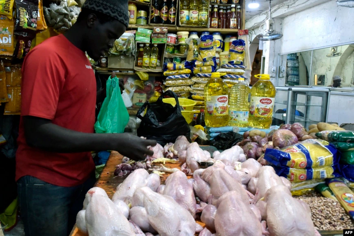 Un vendeur de poulets prépare des viandes à vendre sur un marché de Bambilors à Dakar, le 4 mai 2018. (Photo VOA)