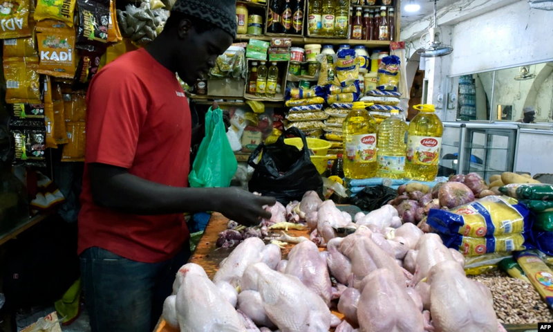 Un vendeur de poulets prépare des viandes à vendre sur un marché de Bambilors à Dakar, le 4 mai 2018. (Photo VOA)