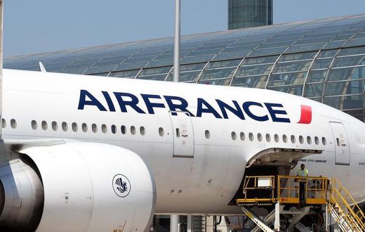Airport workers load an Air France Boeing 777 parked in the tarmac at Charles de Gaulle Airport in Paris.
