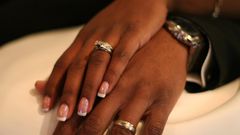 A stock photo of a couple showing off their wedding rings.