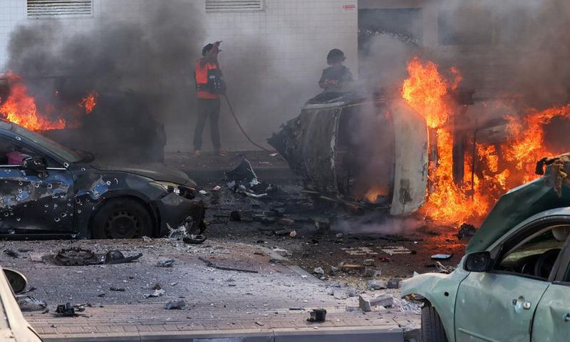 People try to extinguish a fire in Ashkelon, Israel, after Hamas launched a series of surprise attacks on October 7.Ahmad Gharabli/AFP via Getty Images