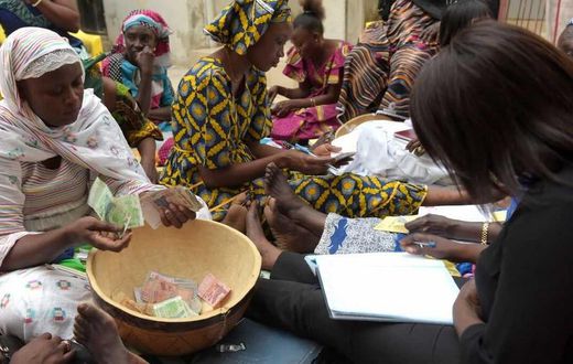 Des femmes comptent l'argent pour la cagnotte de la tontine