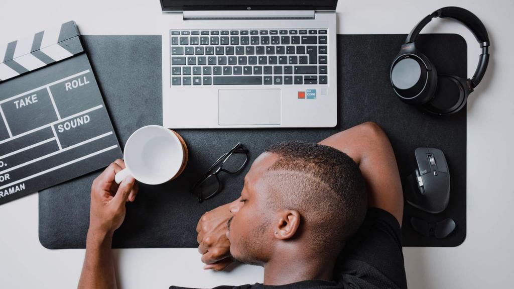 a-man-sitting-at-a-desk-with-a-laptop-and-headphones-stockpack-unsplash-scaled