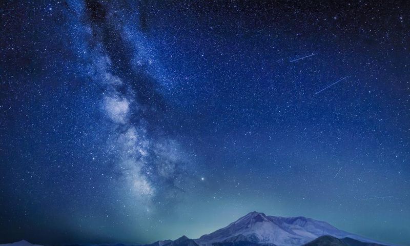 The Delta Aquariids meteor shower and Milky Way over Mount St. Helens, at Windy Ridge in Washington State with Mt. Hood, Oregon visible in the lower left corner. In 2023, it's occurring at the same time as the Alpha Capricornids shower.Diana Robinson P...