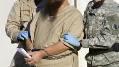 A detainee is escorted by military guards at the US prison at Guantanamo Bay, Cuba, in a 2006 photo