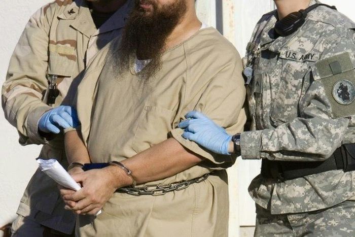A detainee is escorted by military guards at the US prison at Guantanamo Bay, Cuba, in a 2006 photo