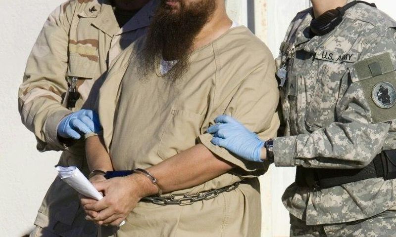A detainee is escorted by military guards at the US prison at Guantanamo Bay, Cuba, in a 2006 photo
