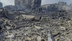 Des Palestiniens marchent dans les décombres des bâtiments détruits par les frappes aériennes israéliennes dans la ville de Gaza, mardi 10 octobre AP Hassan Eslaiah