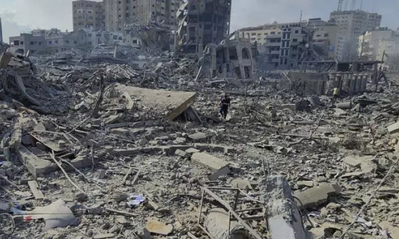 Des Palestiniens marchent dans les décombres des bâtiments détruits par les frappes aériennes israéliennes dans la ville de Gaza, mardi 10 octobre AP Hassan Eslaiah
