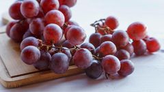 fruits-de-raisin-rouge-frais-sur-fond-de-bois-gratuit-photo