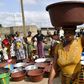An Ivorian woman carries a heavy load after a distribution of safe drinking water in Bouake in early June