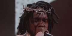 Kendrick Lamar avec le visage ensanglanté porte une couronne en diamant lors d'un show