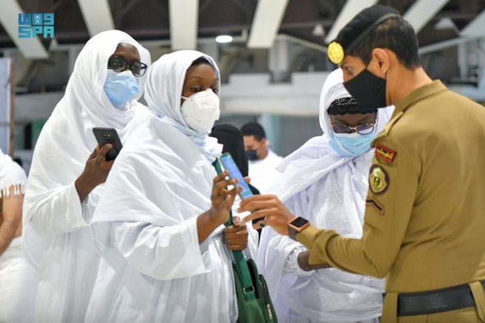 Un membre de la police saoudienne vérifie les détails de la vaccination des pèlerins sur leur smartphone, à la Grande Mosquée, dans la ville sainte de La Mecque, en Arabie saoudite, le 17 octobre 2021 SAUDI PRESS AGENCY