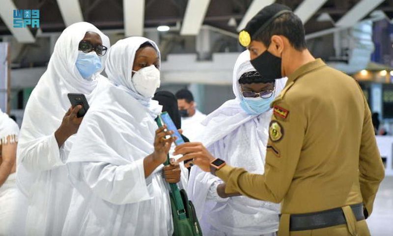 Un membre de la police saoudienne vérifie les détails de la vaccination des pèlerins sur leur smartphone, à la Grande Mosquée, dans la ville sainte de La Mecque, en Arabie saoudite, le 17 octobre 2021 SAUDI PRESS AGENCY