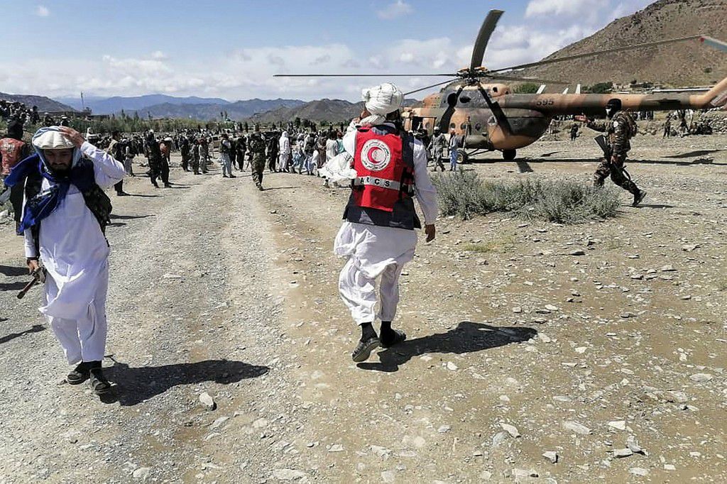 Des soldats et des responsables de la Croix-Rouge afghane se tiennent près d'un hélicoptère dans une zone touchée par un tremblement de terre dans le district de Gayan, dans la province de Paktika © AFP