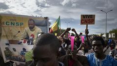 Supporters of the junta, which calls itself the CNSP (National Committee for the Salvation of the People), walk past a banner depicting its leader Assimi Goita in a rally in Bamako on Wednesday